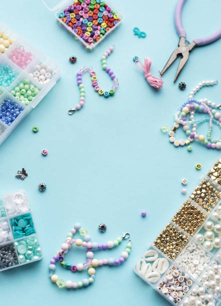 istock Colorful assortment of beads and jewelry-making tools on a blue surface with completed bracelets 2186370221