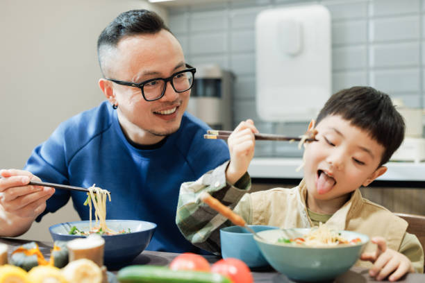 istock happy young father and son are having lunch at home 2186370295