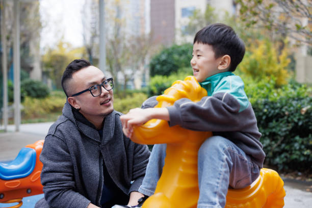 istock young father playing with son in the park 2186370316