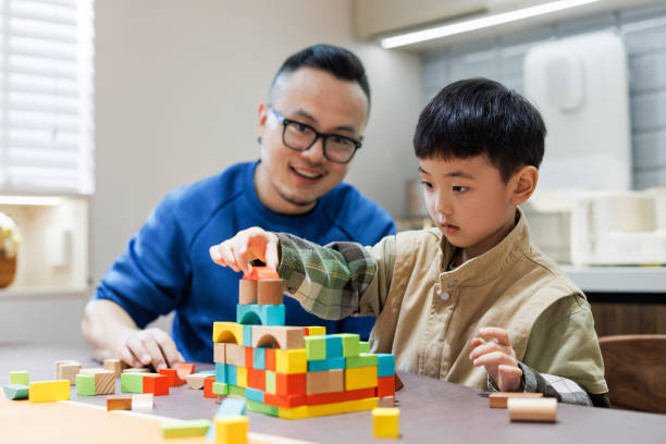 young father and son are building blocks at home stock photo