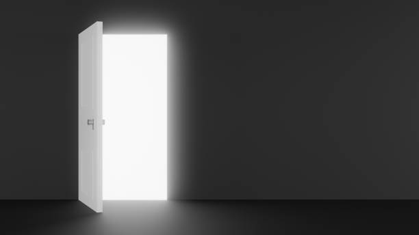 A white door opens into a dark hallway, revealing a bright light. A powerful metaphor for new beginnings, opportunities and hope. Perfect for graphic design projects and inspirational campaigns.