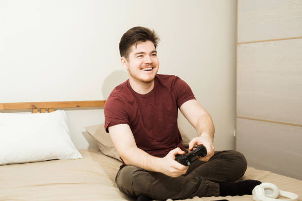 istock Excited young handsome man playing video game sitting on the couch at home. 2186374062