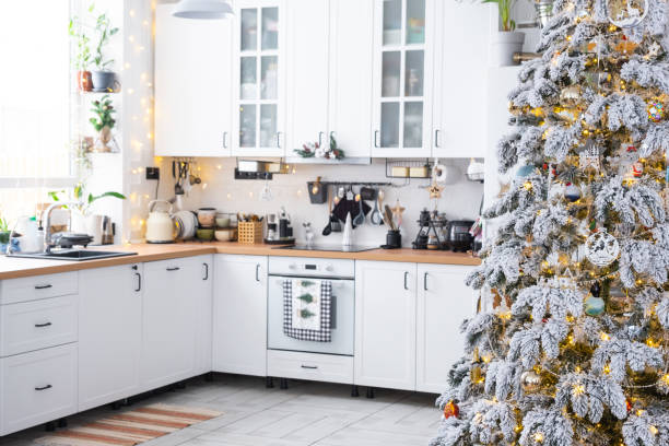 istock Festive Christmas decor in white kitchen, modern rustic interior with a snowy Christmas tree and fairy lights. New Year, Christmas mood, cozy home. The general plan 2186376343