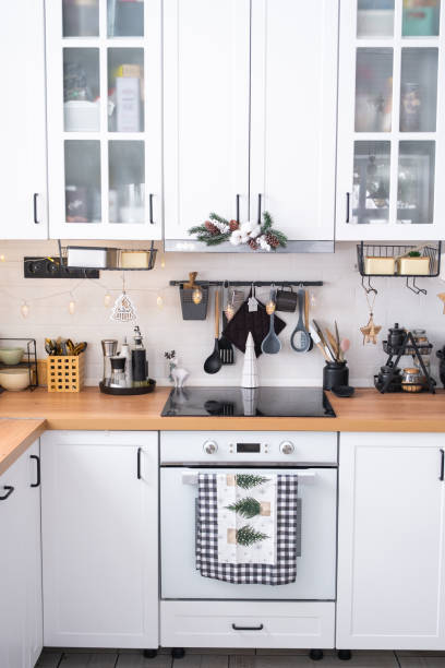 istock Festive Christmas decor in white kitchen, modern rustic interior with a snowy Christmas tree and fairy lights. New Year, Christmas mood, cozy home. The general plan 2186376347