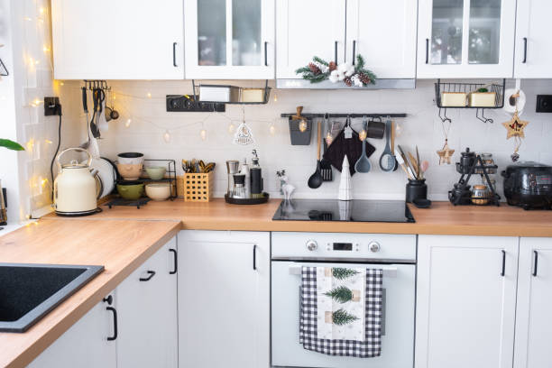 istock Festive Christmas decor in white kitchen, modern rustic interior with a snowy Christmas tree and fairy lights. New Year, Christmas mood, cozy home. The general plan 2186376358