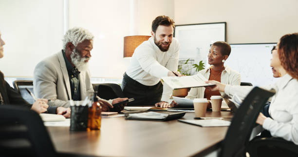 istock Documents, handout and workshop with business people in boardroom of office for coaching or training. Collaboration, diversity and meeting with professional employee group in corporate workplace 2186379041