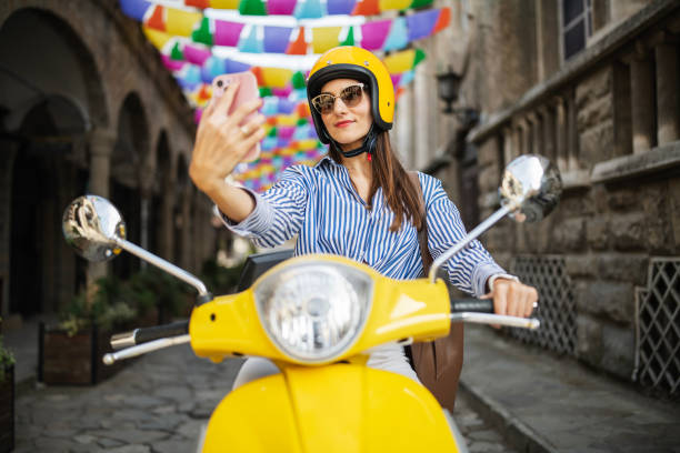 istock Woman taking selfie on yellow scooter. 2186379166