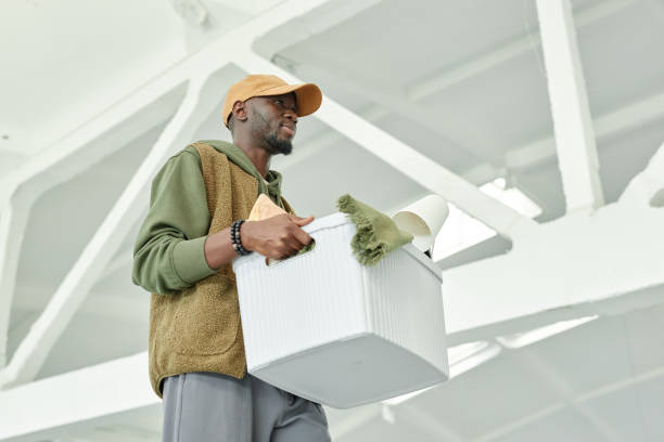 istock Smiling Black Man Carrying Box with Home Items towards Self Storage Unit at Warehouse 2186388605