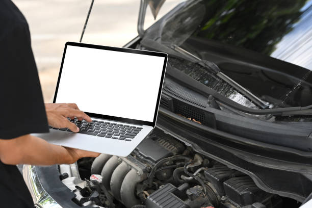 istock Close up of mechanic using laptop to diagnose car engine issues 2186400366