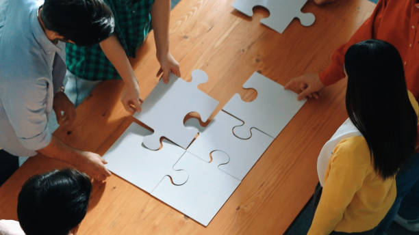 istock Top down view of business people gathering jigsaw piece together. Convocation. 2186402983