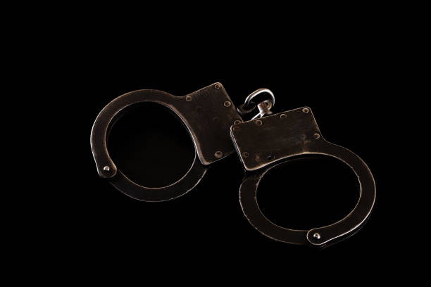 Black steel handcuffs on a black background