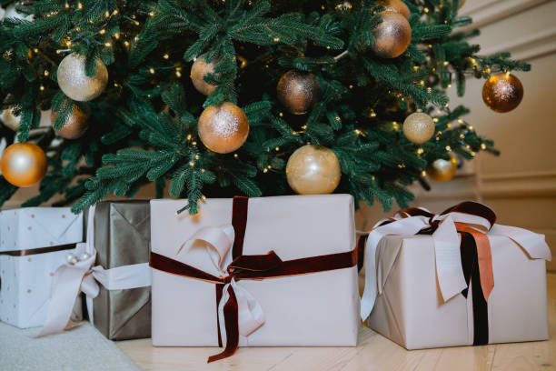 istock Festively wrapped presents beneath an elegantly decorated Christmas tree 2186409528