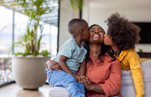 istock Affectionate boys kissing their mother at home 2186412076