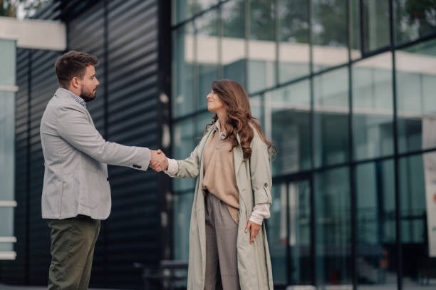istock Business people shaking hands outside office building 2186416561