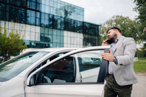 istock Businessman talking on the phone while exiting car 2186416598