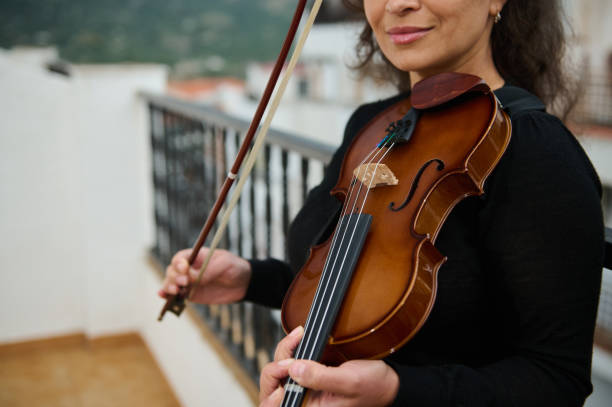 istock Woman practicing violin on a balcony with scenic view 2186417697