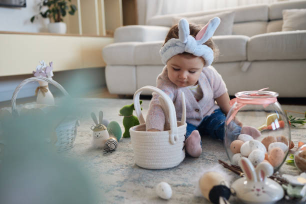 Playful caucasian girl decorating for Easter. She is in the domestic room, collecting eggs.