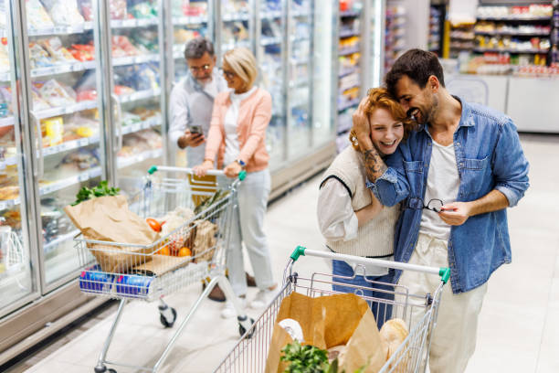 istock Happy couple embracing while shopping in supermarket, 2186420746
