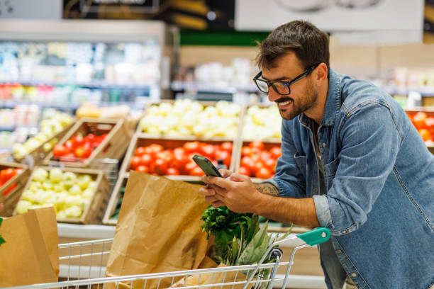 istock Customer using smartphone while shopping for groceries in supermarket 2186420800