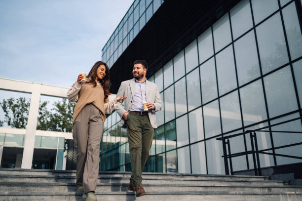 istock Businesspeople walking and talking while holding coffee cups 2186421204