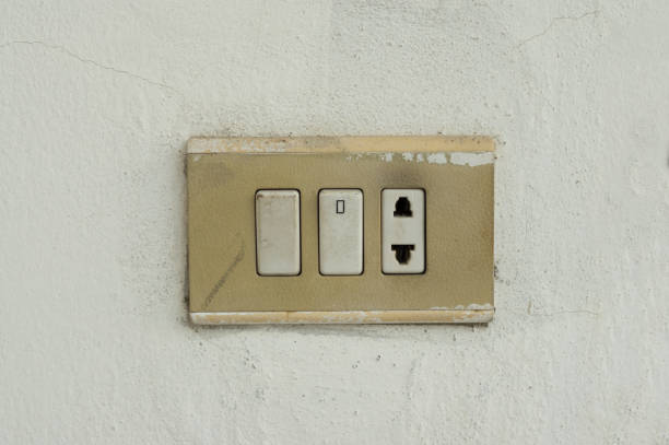 istock Old turned on light switch with electric outlet on wall. 2186427935