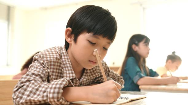 istock Close up of smart asian student writing or taking a note during test. Pedagogy. 2186432146