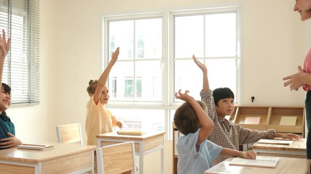 istock Diverse smart student raised hands to answer question at classroom. Pedagogy. 2186433142