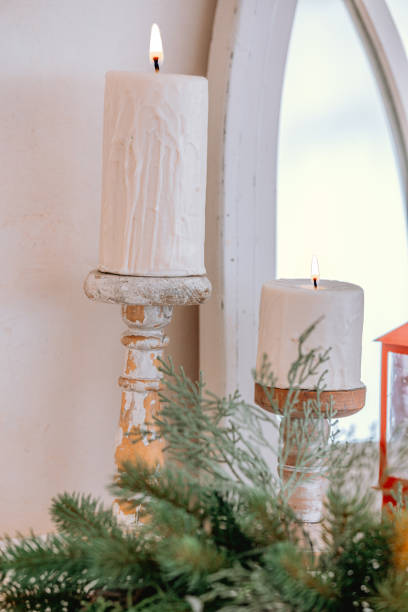 istock Elegant white candles on rustic holders with greenery and mirror reflection 2186439762
