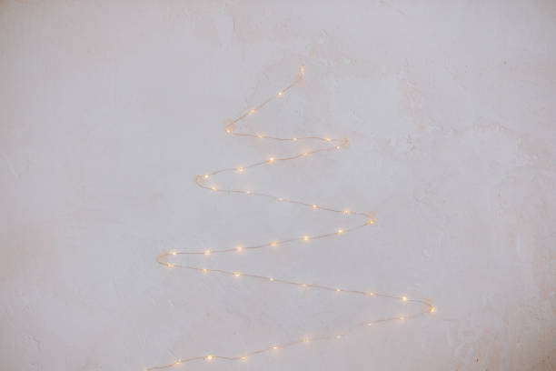 istock Strung fairy lights create a whimsical tree shape on a textured wall 2186439764