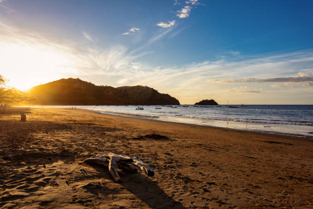 Evening view of the Pacific Coast, Del Coco beach with sunset and glittering waves . Idyllic sunset landscape. Coco Costa Rica. Pura Vida concept, travel to exotic tropical country.