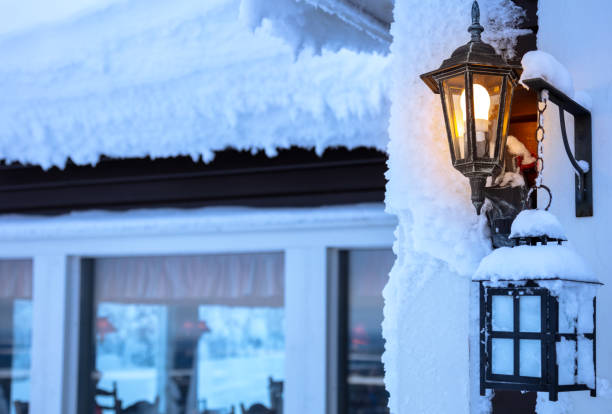 A winter cafe with a thick cap of snow on the roof and two snow-covered lanterns