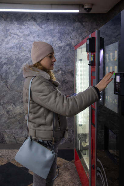istock Woman stands by coffee vending machine 2186444699