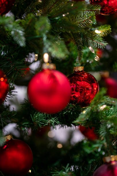istock Green artificial fir branches decorated with red balls with garland lights 2186453792