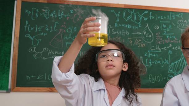 istock Attractive american student hold beaker and inspect colored solution. Pedagogy. 2186454411