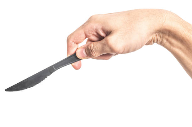 istock Male hand holding a black plastic cooking knife isolated on white background. 2186454970