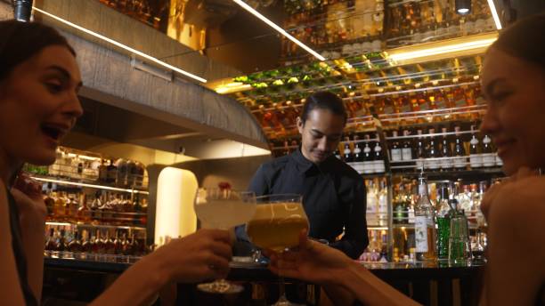 istock Asian bartender mixed vodka cocktail glass serving beautiful customer. Vinosity. 2186455023