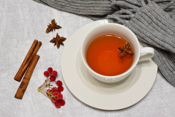 istock a cup of tea with some berries next to some cinnamon sticks 2186455774