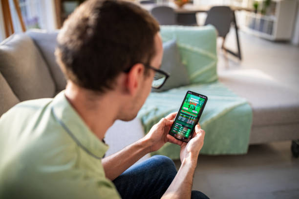 istock Focused man checking live game scores on smartphone 2186456434