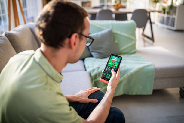 istock Man looking at smartphone displaying sports scores 2186457477