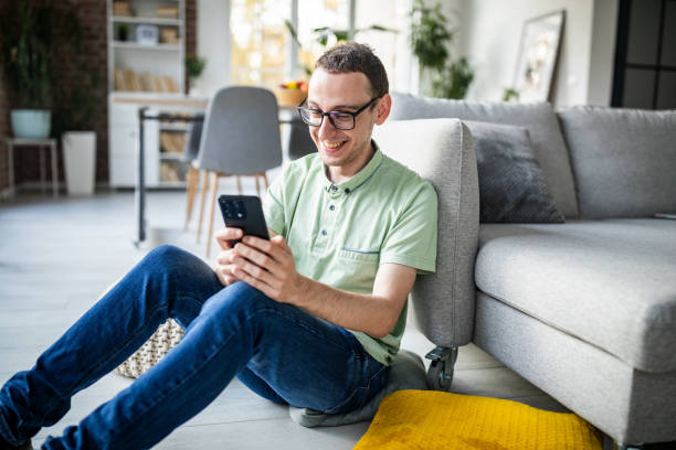 istock Relaxed young adult using phone in a cozy home 2186458658