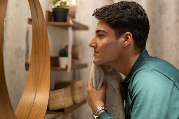 istock Young man drying his face with a towel in the bathroom 2186459229