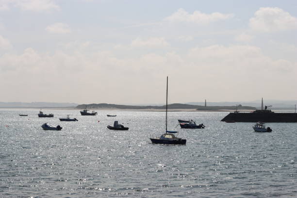 Boats moored on a calm sea glittering in sunlight