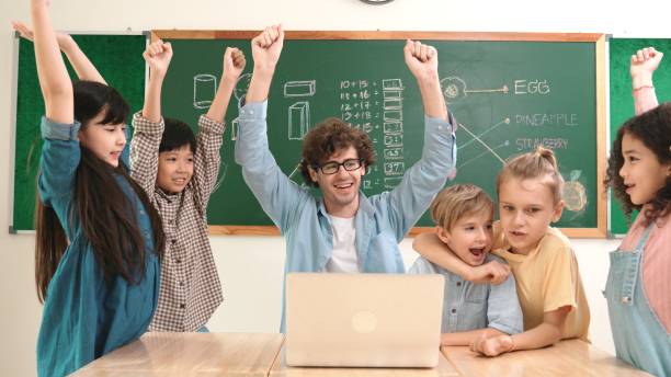 istock Teacher and student looking at laptop while celebrate success project. Pedagogy. 2186463593
