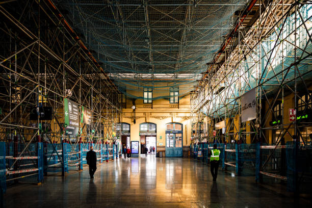 Valencia, Spain. Tuesday,  19th of November 2024: The photo captures the interior of the North Station (Estación del Norte), a historic train station in Valencia, Spain, currently undergoing renovation. Scaffolding fills the space, highlighting the ongoing efforts to preserve and restore this iconic early 20th-century modernist masterpiece. Despite the construction work, the station’s remarkable architectural details are still visible, including its intricate ironwork, vibrant mosaics, and decorative elements inspired by Valencian culture. Situated in the heart of the city, the North Station remains a key transportation hub and an architectural treasure, even amidst the restoration process. This image is ideal for documenting urban development, architectural preservation, or the transformation of historic landmarks.
