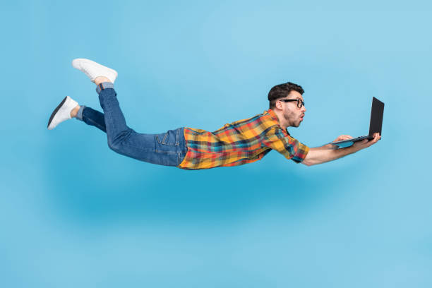 istock Full body profile photo of impressed guy fly fall hold wireless netbook isolated on blue color background 2186473659