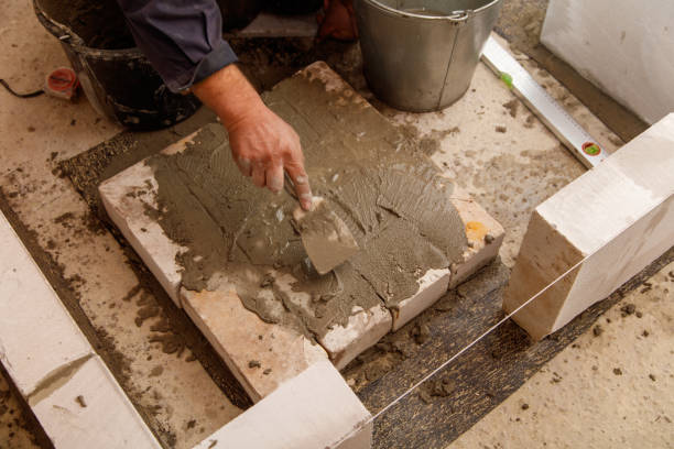 istock A man is laying bricks on a cement slab 2186480853