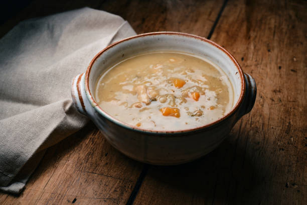 istock Bowl of Chicken, vegetable and grain soup on a rustic wooden table top. 2186484836