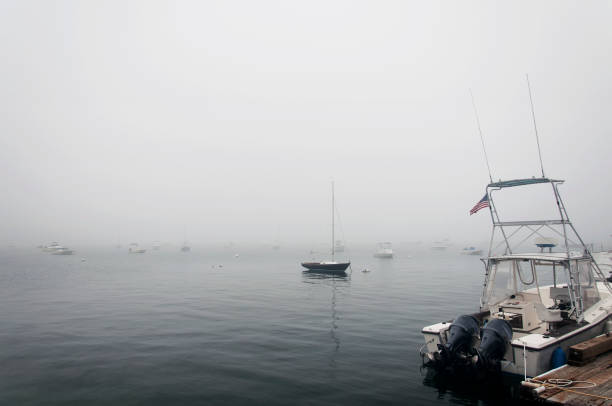 Boats enjoying the late afternoon on Vineyard Sound making a slow approach to Falmouth Harbor in Falmouth, MA on Cape Cod.