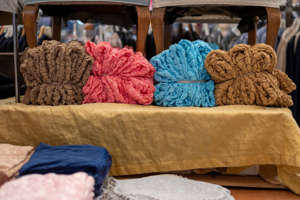 istock Colorful chenille scarves displayed on a table in a boutique 2186487941