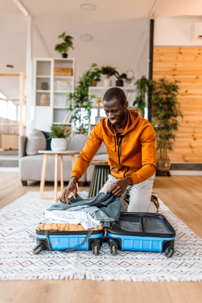istock Young man packing his staff in suitcase, getting ready for business trip. 2186488039